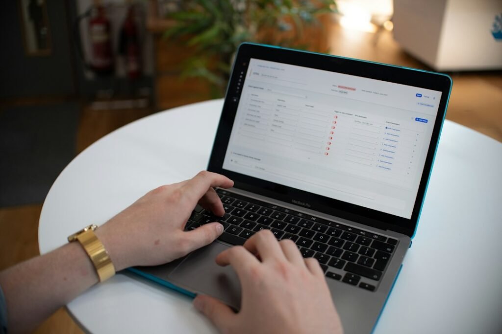 Person working at laptop reviewing structured data table, representing SEMrush Pro's keyword research and reporting features